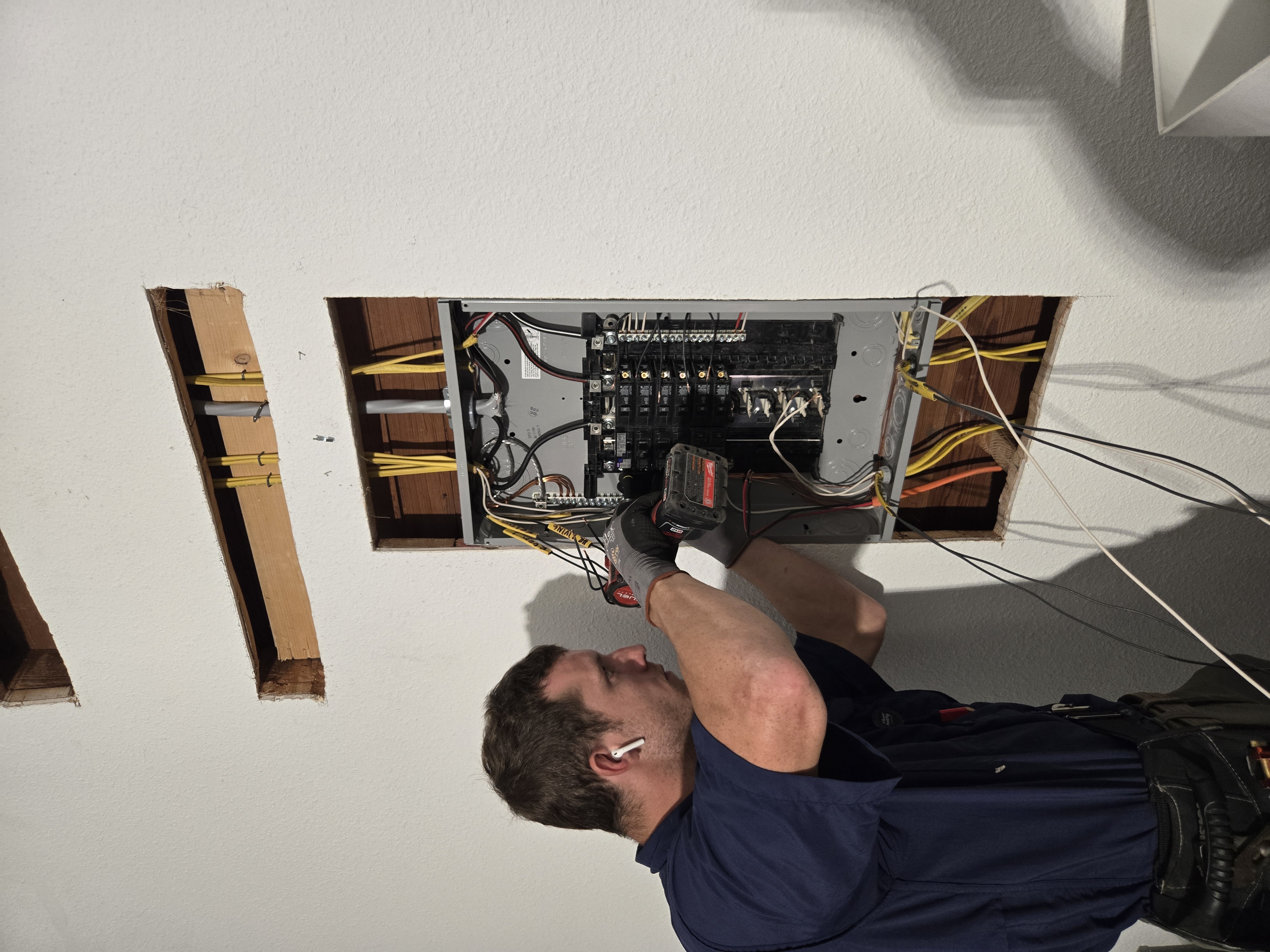 Licensed electrician installing residential electrical panel with professional tools in San Antonio