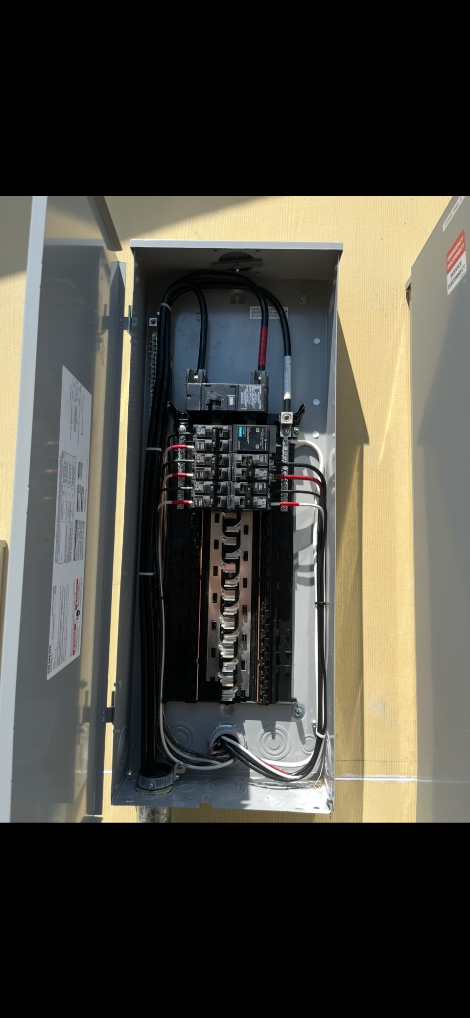 Clean outdoor electrical panel installation with organized wiring and code compliance