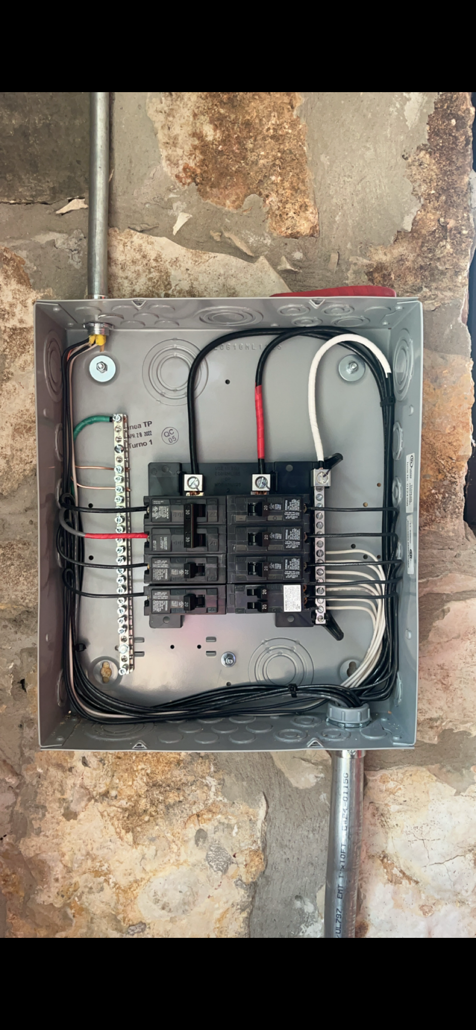 Outdoor electrical panel installation on concrete wall with professional wiring by licensed electrician
