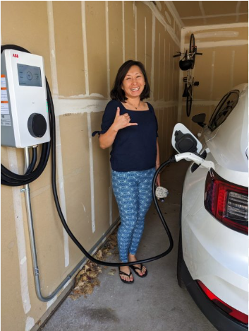 Happy customer with newly installed residential EV charging station in garage for electric vehicle